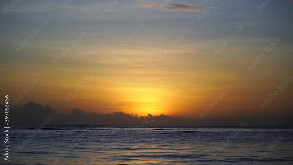Beautiful sunrise over the Indian Ocean on the island of Zanzibar, Tanzania, east Africa. Travel and nature concept. Sun, blue sky and sea water Beautiful sunrise over the Indian Ocean on the island of Zanzibar, Tanzania, east Africa. Travel and nature concept. Sun, blue sky and sea water