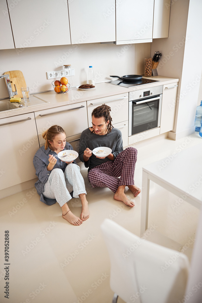Beautiful young couple enjoying breakfast in kitchen Beautiful young couple enjoying breakfast in kitchen