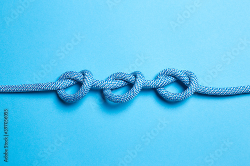 Three knots on a rope on a blue background.
