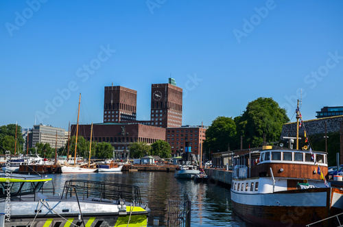 View of Radhuset town hall, harbour fjord and marinas of Aker Brygge  with ships in the foreground. Oslo, Norway 