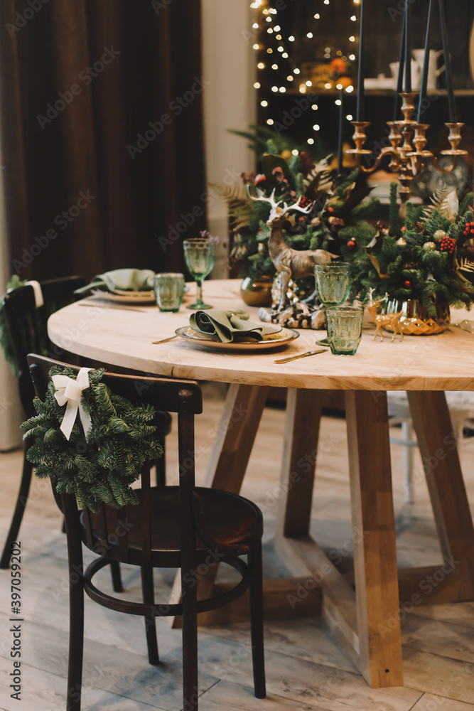 Obraz premium Festive kitchen in Christmas decorations. Christmas dining room. Beautiful New Year decorated classic home interior