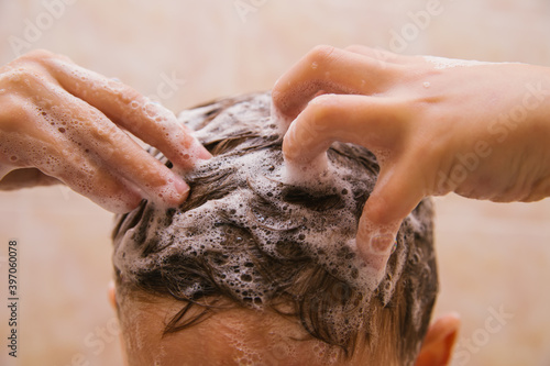 The child washes his head with shampoo. Soap foam on the hair. Hair care.