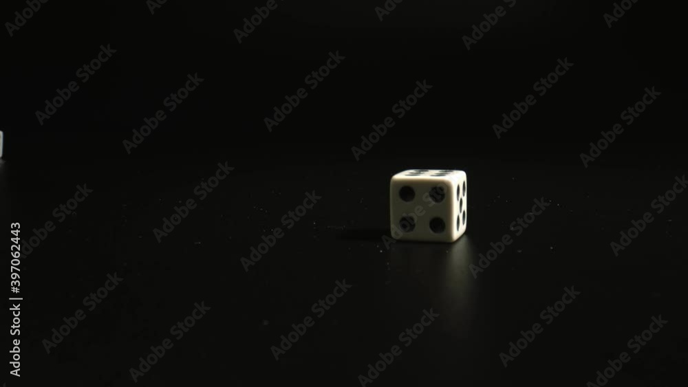 Close up of throwing dices on black background in casino. Gambling addiction concept. White dices with black background. high quality. Close up of throwing dices on black background in casino. Gambling addiction concept. White dices with black background. high quality.