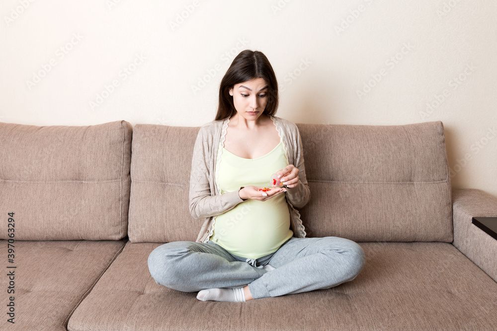 Pregnant woman with pills in hand, healthcare concept, medicine during pregnancy