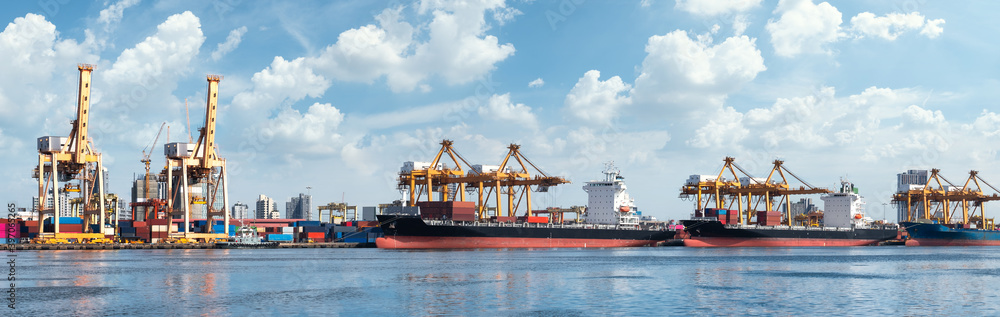 Panorama of Container cargo ship with bridge cranes during a sunny day . import export and international transport industry . containers terminal .