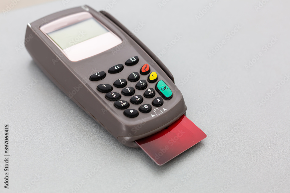 Online shopping concept. Close-up of a cash register next to a cart on a gray background, top view, copy space Online shopping concept. Close-up of a cash register next to a cart on a gray background, top view, copy space