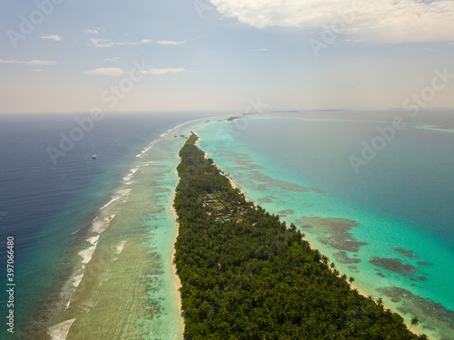 Aerial spherical panorama of tropical paradise beach on tiny Maldives island. Turquoise ocean, white sand, coconut palm trees.