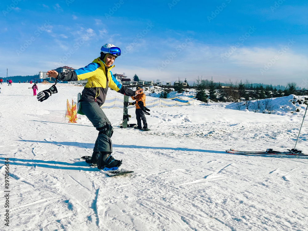 woman riding on snowboard down by hill