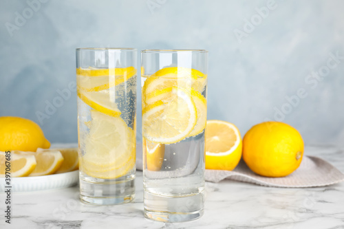 Soda water with lemon slices on white marble table