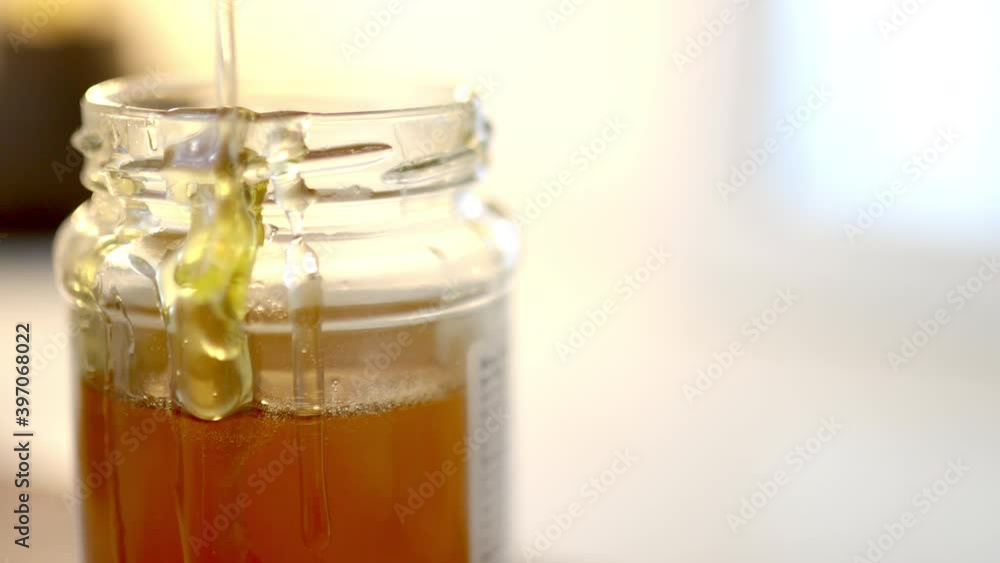 Knife pouring honey on the edge of a jar Knife pouring honey on the edge of a jar