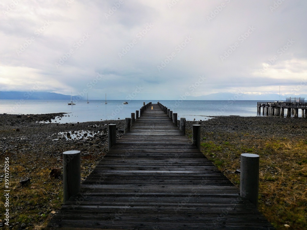 Perspective looking out at an empty pier on Lake Tahoe on a stormy day 