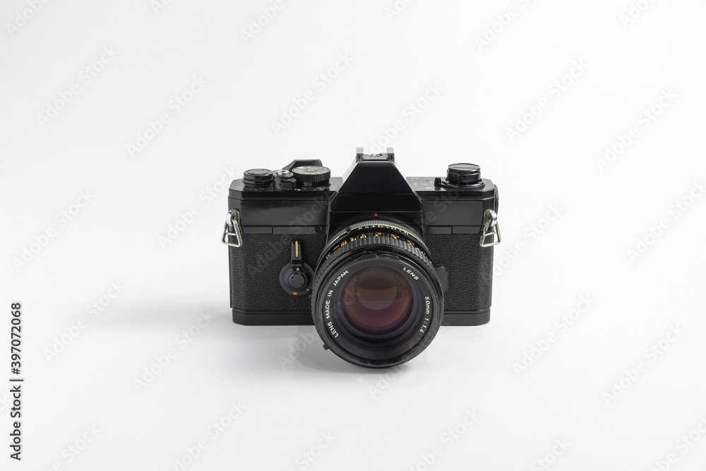 Classic vintage black film SLR camera with 50mm lens attached isolated in white background. 