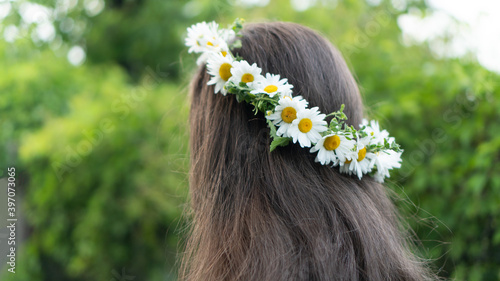 Obraz na plátně A young woman with beautiful shining brown long hair is walking in the Park