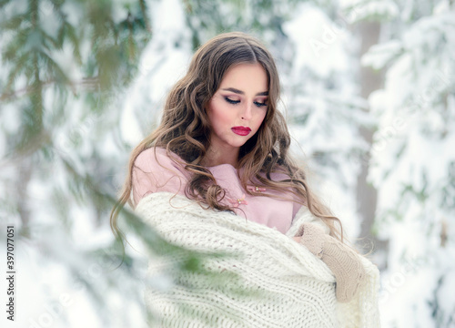 Beautiful romantic woman in a white plaid. Winter beauty portrait in a snow forest