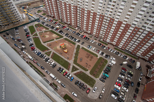 Wrong designed yard of the apartment house is full of cars, aerial view.