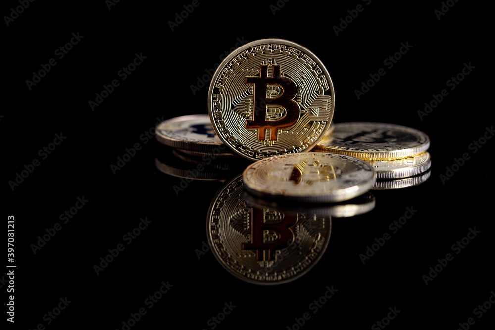 Bitcoin close-up on a black background with a reflective surface.