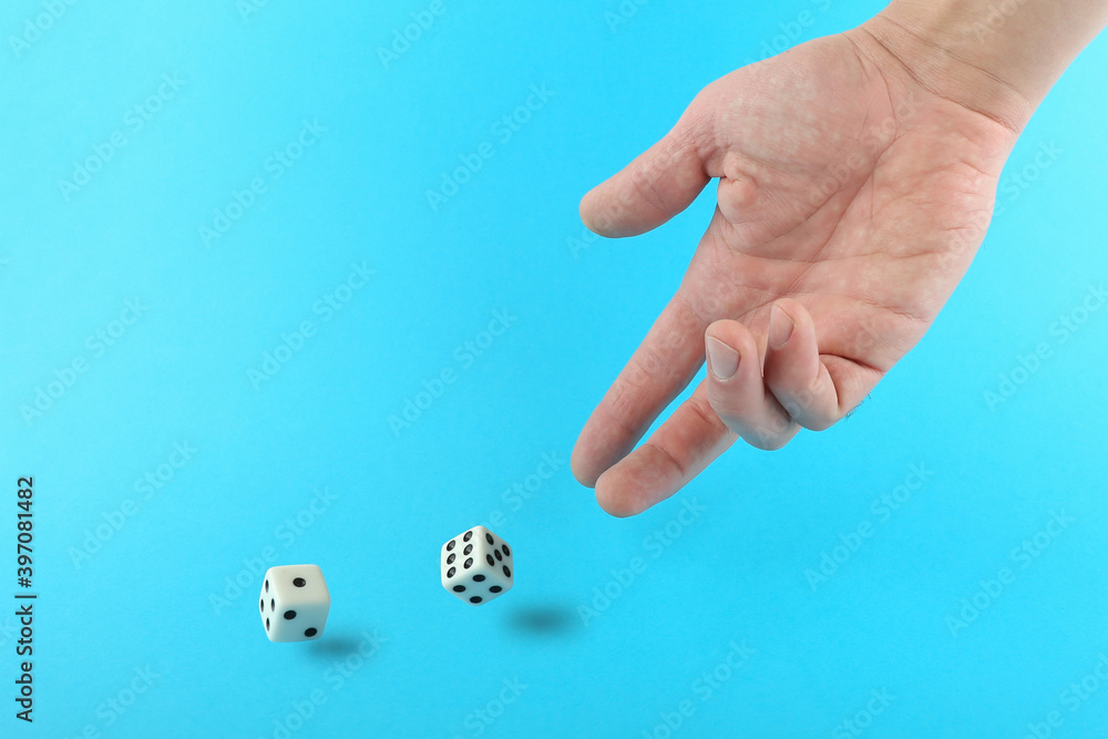 hand throws dice on blue background hand throws dice on blue background