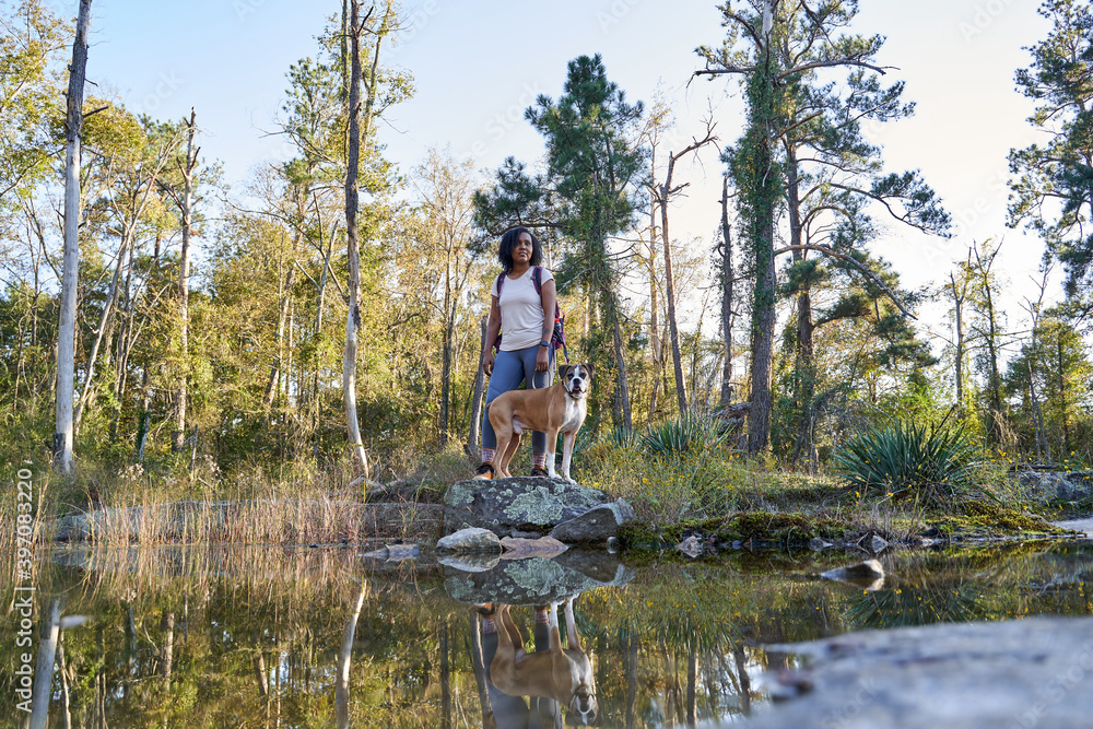 Black woman exploring nature outdoors with pet dog Black woman exploring nature outdoors with pet dog