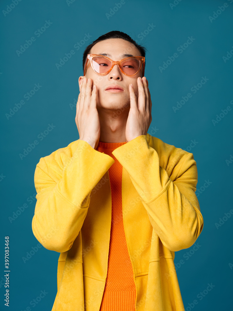 A man with glasses tilted his head back yellow jacket blue background A man with glasses tilted his head back yellow jacket blue background