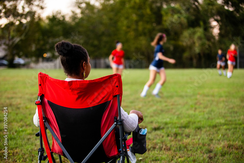 Supportive mom watches daughters play soccer