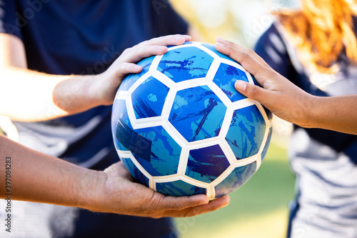 Soccer team hands huddled on ball photo