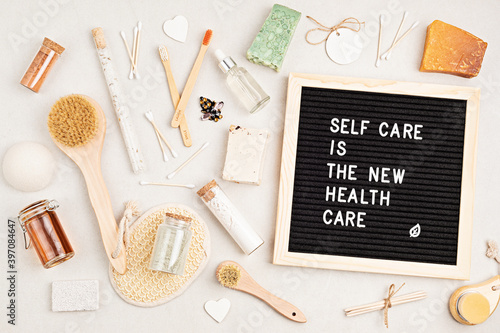 Self care is the new health care. Motivational quote on black letter board with variety of organic body and face care products. Natural homemade eco friendly beauty products photo