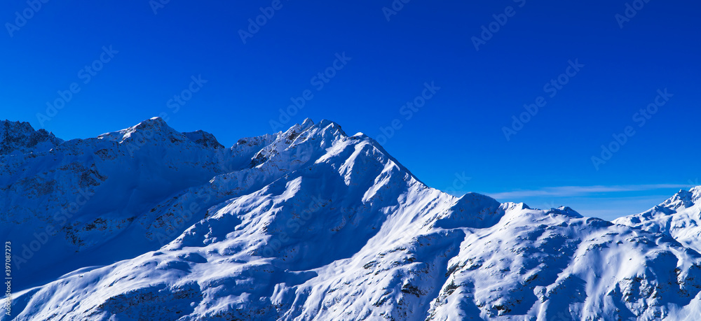 Magical dark blue Austrian Alps panorama - peaks and snowy mountains near Zürs, Austria