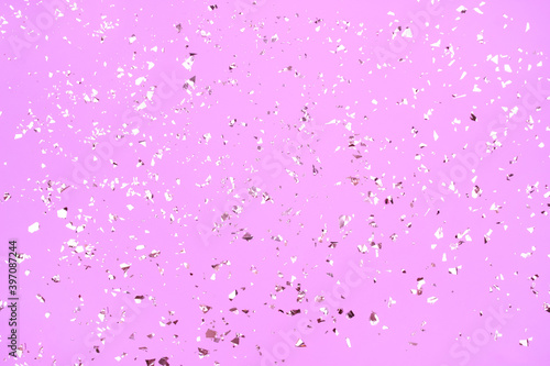 Festive background in pink color with holographic flying silver sparkles for your project. Holiday backdrop with copyspace. Birthday party  Christmas or New Year celebration concept