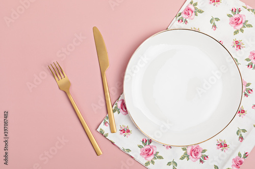 Empty white plate and cotton napkin on pink backdrop. Food background for menu, recipe book. Table setting. Flatlay, top view