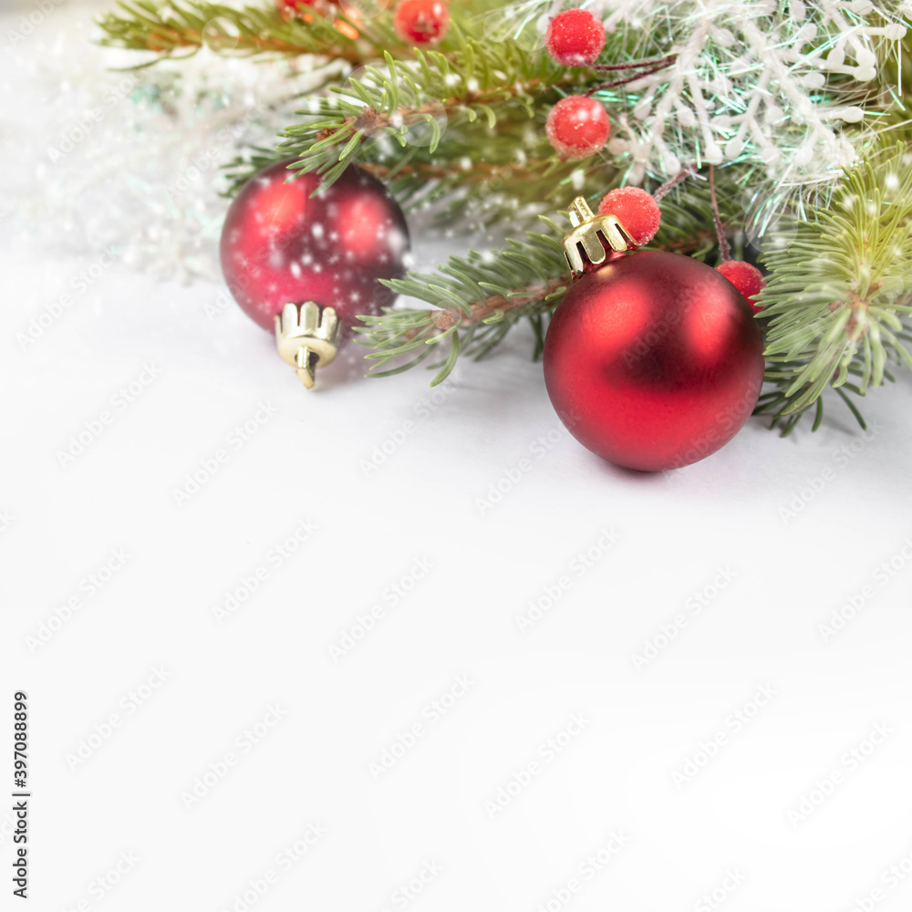 Christmas card with a green branch of a Christmas tree and red round toys on a white background. Christmas card with a green branch of a Christmas tree and red round toys on a white background.