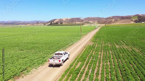 Good aerial of a pickup truck driving through farm fields in Lompoc, Santa Barbara County, California.