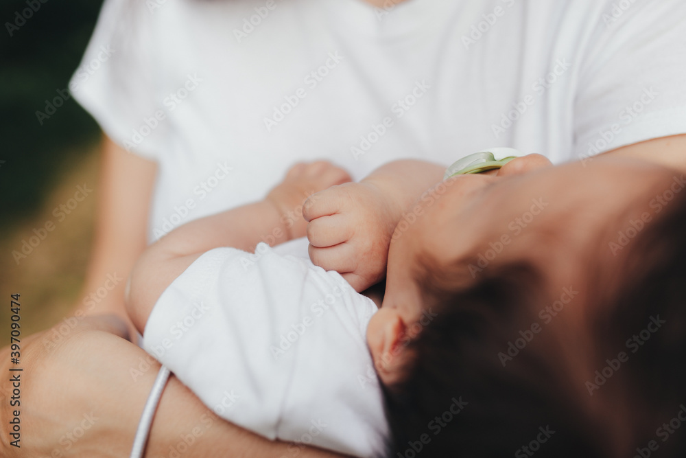 Fototapeta premium Little baby's hands, mother with baby, care of baby, mother carrying baby