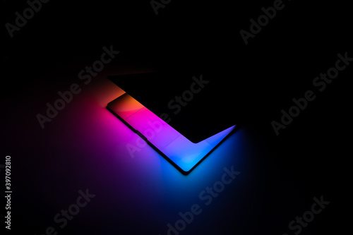 Opened MacBook illuminated with gradient