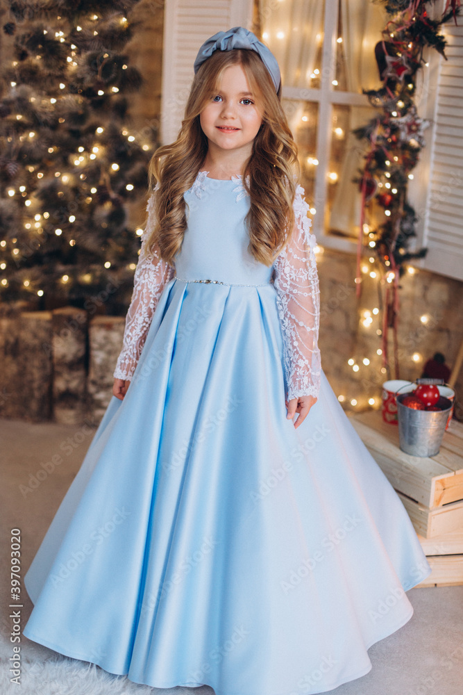Fototapeta premium Little cute happy adorable girl in elegant fashion dress in christmas decorations. Christmas holidays, celebaration concept