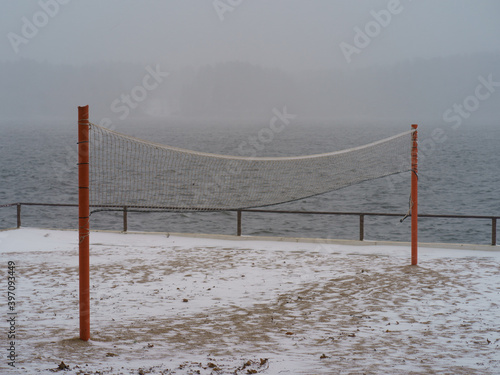 Blizzard in the touristic resort. Snowy Russian winter coming. River bank had been covered by snow. Weather forecast - snow with rain. Concept of  the beauty in nature despite the bad weather. photo