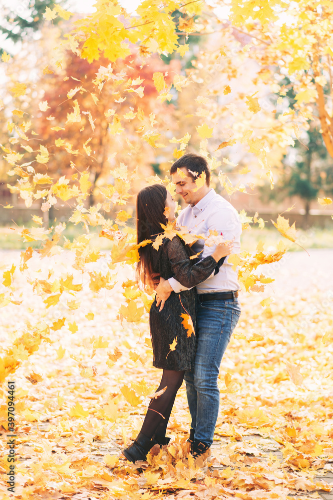 Happy couple in love and falling maple leaves in autumn park Happy couple in love and falling maple leaves in autumn park