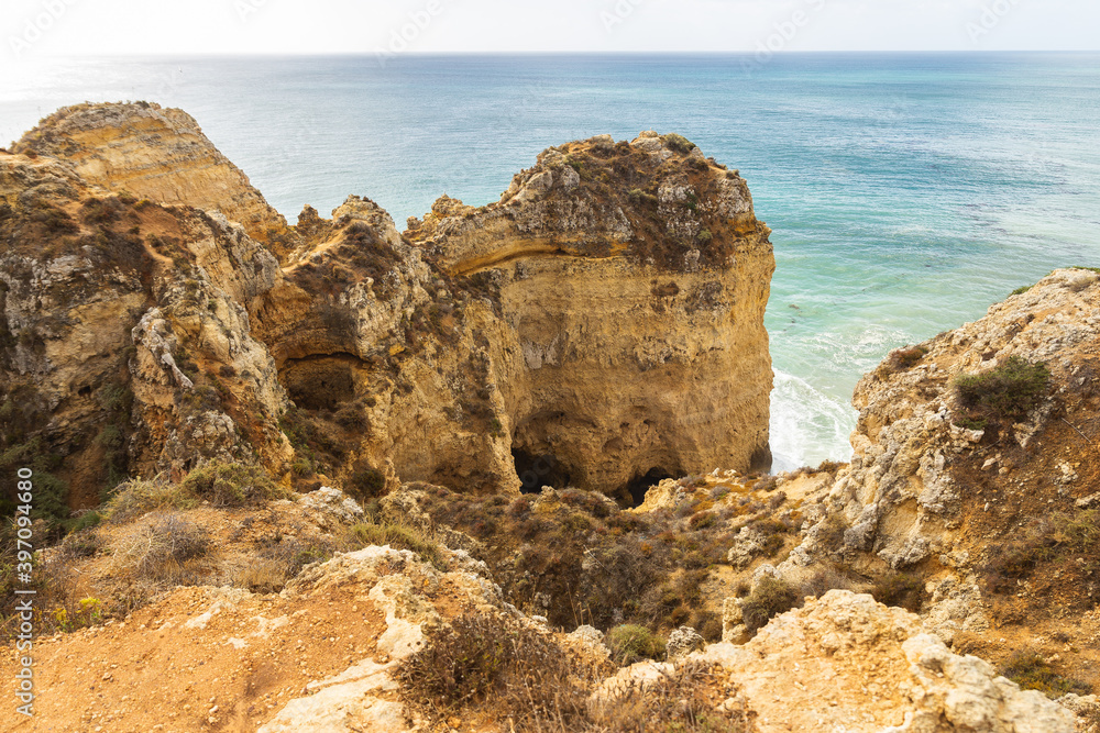 Portugal Lagos Atlantic ocean shore waves crushing rocks mountains hills greens blue water Ponta da Piedade sunny day rock mountains hill formation Portugal Lagos Atlantic ocean shore waves crushing rocks mountains hills greens blue water Ponta da Piedade sunny day rock mountains hill formation