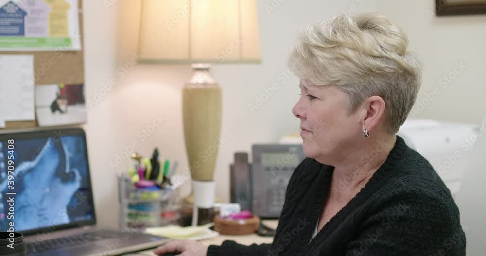 Caucasian businesswoman at desk turning and smiling Caucasian businesswoman at desk turning and smiling