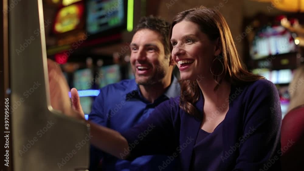 Caucasian couple winning at slot machine Caucasian couple winning at slot machine