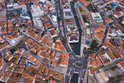 drone shot aerial view from above look Aveiro Portugal cloudy day city center rooftops orange red Monumento ao Marnoto e à Salineira
