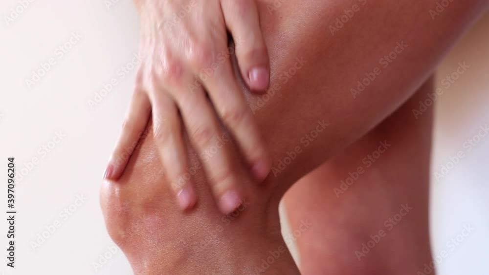 Close up of woman rubbing lotion into leg Close up of woman rubbing lotion into leg