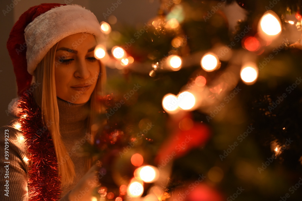 The girl decorates the Christmas tree with candles and decorations The girl decorates the Christmas tree with candles and decorations