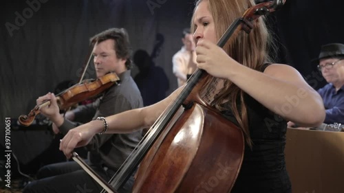 Band playing stringed instruments in studio space photo