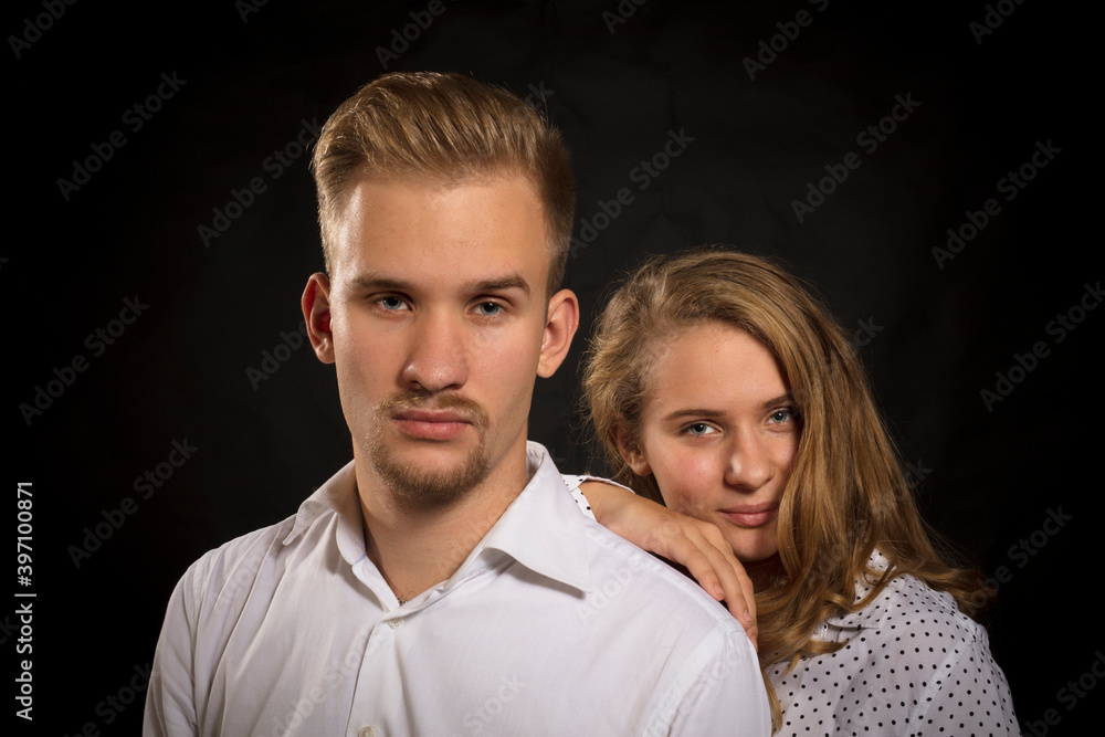 Young beautiful couple studio portrait on black background. Young beautiful couple studio portrait on black background.