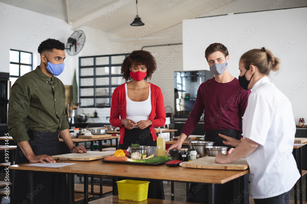 Female chef and divserse group wearing face masks in kitchen Female chef and divserse group wearing face masks in kitchen