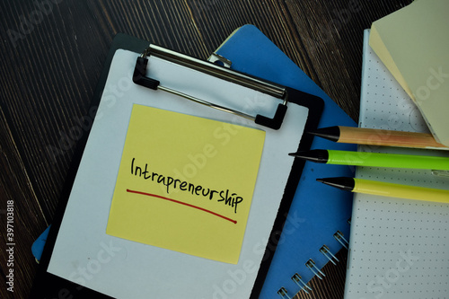 Intrapreneurship write on sticky notes. Isolated on Wooden Table. photo