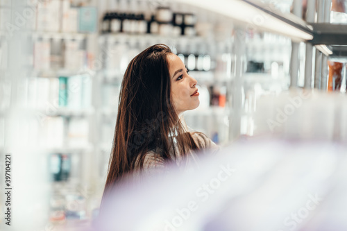 beautiful smiling Asian girl chooses buys cosmetics in the store. shopping