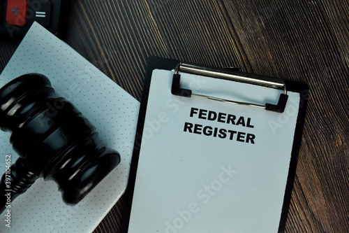 Federal Register write on a paperwork isolated on Wooden Table. Business Concept