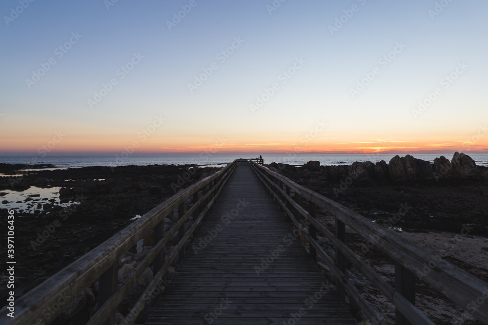 Praia do Coral sunset Viana do Castelo Portugal shore coast beach rocks sand footbridge pathway wooden blue violet sky