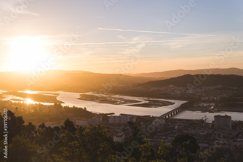 sunrise over Viana do Castelo Portugal city hills mountains Limia river Ponte Eiffel bridge blue sky sunshine 